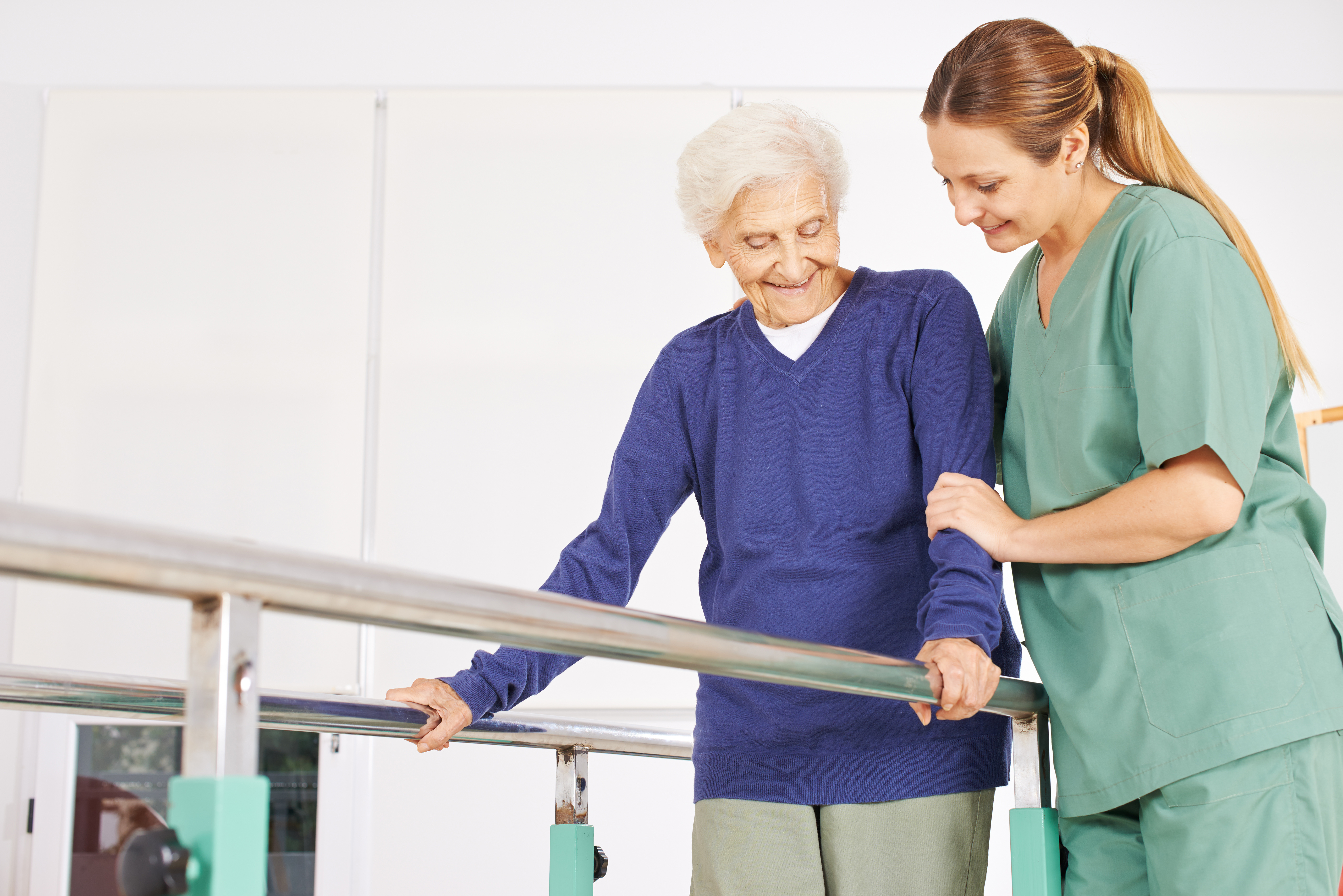 Fisioterapeuta acompaña en un ejercicio a una persona mayor